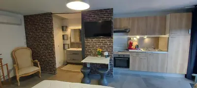 a kitchen with a table and a brick wall at Corse et Zen BULLE ZEN 25 m² 2 pers + Bébé in Folelli