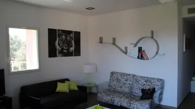 a living room with a chair and a mirror at La corse les pieds dans l'eau in Sainte-Lucie de Porto-Vecchio