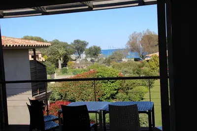 a view of a table and chairs on a balcony at La corse les pieds dans l'eau in Sainte-Lucie de Porto-Vecchio