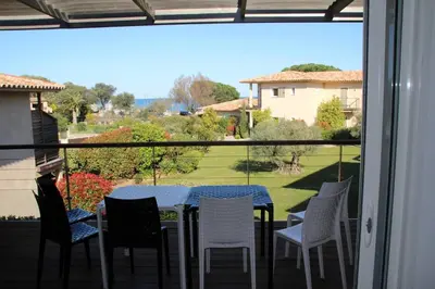 a table and chairs on a balcony with a view at La corse les pieds dans l'eau in Sainte-Lucie de Porto-Vecchio