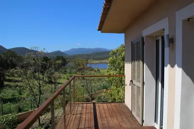 a balcony of a house with a view of a lake at La corse les pieds dans l'eau in Sainte-Lucie de Porto-Vecchio