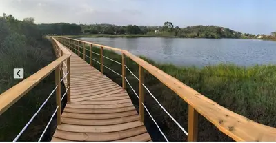 a wooden bridge over a body of water at La corse les pieds dans l'eau in Sainte-Lucie de Porto-Vecchio