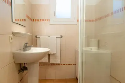 a white bathroom with a sink and a shower at Résidence Marie Diane - Laurier des Mers in Propriano