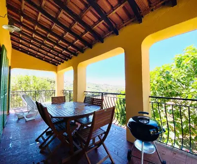 a dining room with a table and chairs on a balcony at Résidence Marie Diane - Laurier des Mers in Propriano