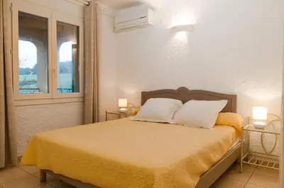 a bedroom with a bed with two pillows and a window at Résidence Marie Diane - Laurier des Mers in Propriano