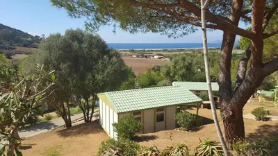 a small white house with a green roof at CAMPING U SOMMALU in Casaglione