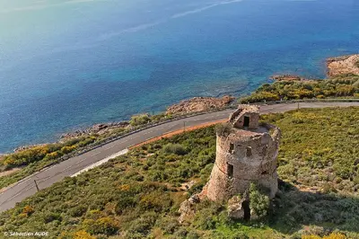 an old castle on a hill next to a road at CAMPING U SOMMALU in Casaglione