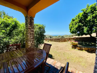 a wooden table and chairs on a patio at Résidence Marie Diane - Laurier des Bois in Propriano