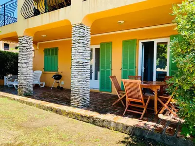 a patio with a table and chairs in front of a house at Résidence Marie Diane - Laurier des Bois in Propriano