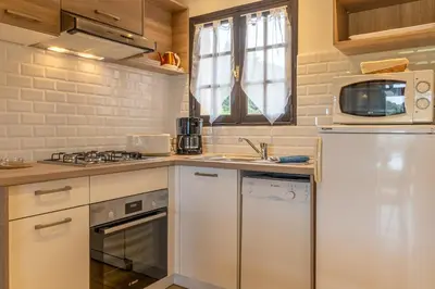 a kitchen with a white refrigerator and a sink at Résidence Marie Diane - Duplex Vue Piscine A in Propriano