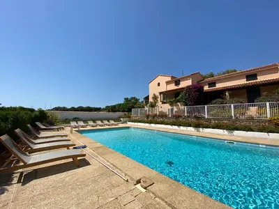 a swimming pool with lounge chairs and a building at Résidence Marie Diane - Duplex Vue Piscine A in Propriano
