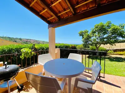 a patio with a table and chairs on a balcony at Résidence Marie Diane - Duplex Coté Mer C in Propriano