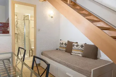 a bench under the stairs in a house at Résidence Marie Diane - Duplex Coté Mer C in Propriano