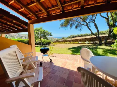 a patio with a table and chairs and a grill at Résidence Marie Diane - Duplex Coté Mer D in Propriano