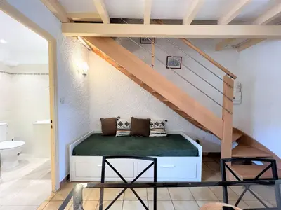 a bedroom with a bed under a staircase at Résidence Marie Diane - Duplex Coté Mer D in Propriano