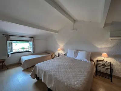 a bedroom with two beds and a window at Résidence Marie Diane - Duplex Coté Mer E in Propriano