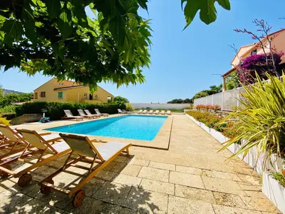 a swimming pool with lounge chairs next to a house at Résidence Marie Diane - Duplex Coté Mer E in Propriano