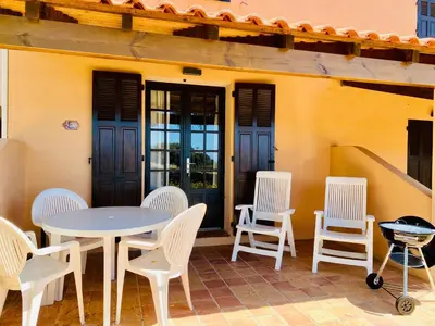 a patio with a table and chairs and a staircase at Résidence Marie Diane - Duplex Coté Mer E in Propriano