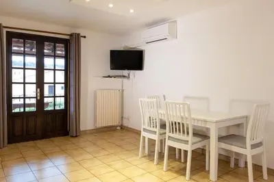 a dining room with a table and chairs and a tv at Résidence Marie Diane - Grand Duplex H in Propriano