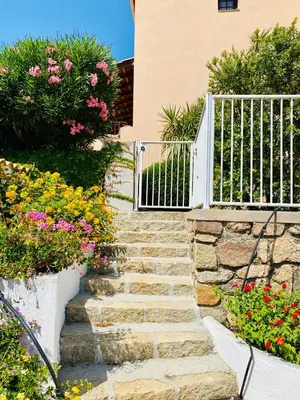 a stone staircase leading to a house with a white gate at Résidence Marie Diane - Grand Duplex H in Propriano