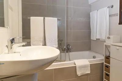 a white bathroom with a sink and a bath tub at Résidence Marie Diane - Grand Duplex H in Propriano