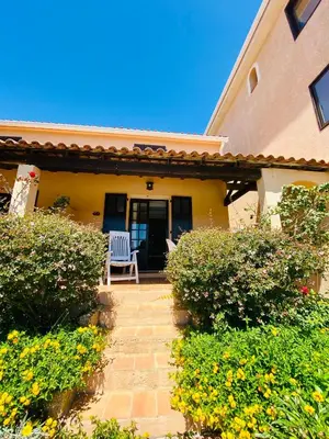 a house with a chair on the front porch at Résidence Marie Diane - Appart vue mer et piscine G in Propriano