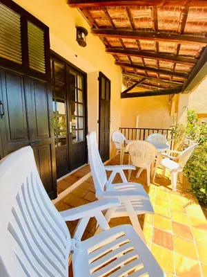 a group of chairs and tables on a porch at Résidence Marie Diane - Appart vue mer et piscine G in Propriano