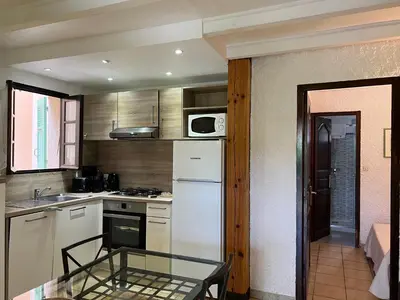 a kitchen with a white refrigerator and a table at Résidence Marie Diane - Appart vue mer et piscine G in Propriano