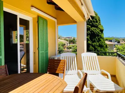 a porch with a table and chairs on a balcony at Résidence Marie Diane - Laurier des Montagnes in Propriano