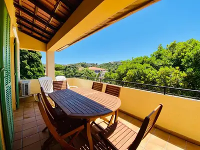 a table and chairs on the balcony of a house at Résidence Marie Diane - Laurier des Montagnes in Propriano