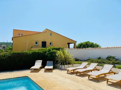 a group of lounge chairs next to a swimming pool at Résidence Marie Diane - Laurier des Montagnes in Propriano