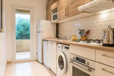 a kitchen with a white refrigerator and a dishwasher at Résidence Marie Diane - Laurier des Montagnes in Propriano