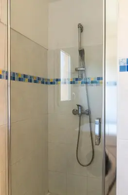 a bathroom with a shower with a glass door at Résidence Marie Diane - Laurier Rose in Propriano