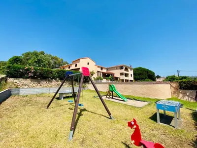 a playground with a toy horse and a swing at Résidence Marie Diane - Laurier Rose in Propriano