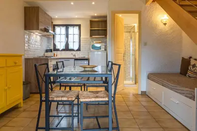 a kitchen with a blue table and some chairs at Duplex vue Piscine B in Propriano