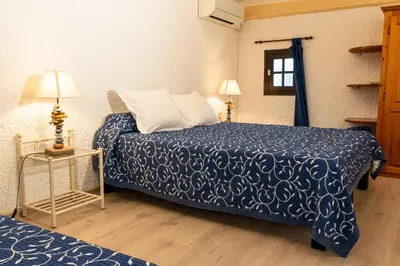 a bedroom with a bed with a blue and white blanket at Duplex vue Piscine B in Propriano