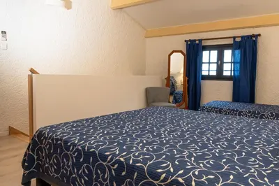 a hotel room with a bed and a mirror at Duplex vue Piscine B in Propriano