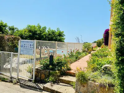 a garden with a white fence and some plants at Duplex vue Piscine B in Propriano