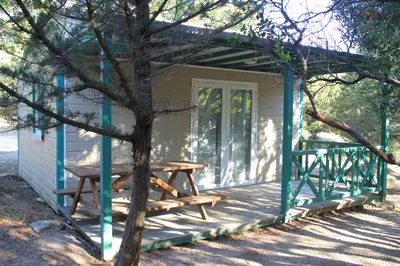 a picnic table on the porch of a tiny house at Location de chalet Meremaki in Pianottoli-Caldarello