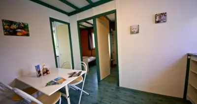 a room with a table and chairs in a room at Location de chalet Meremaki in Pianottoli-Caldarello