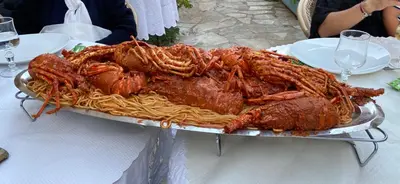 a large platter of meat and pasta on a table at Ajaccio Magnifique T2 45m2 neuf 5 personnes Clim wifi stationnement gratuit centre ville plage à 300m in Ajaccio
