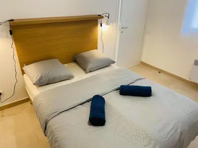 a bed with two blue pillows on top of it at Résidence Marina Di Bravone in Linguizzetta