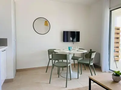 a dining room with a table and chairs and a tv at Résidence Marina Di Bravone in Linguizzetta