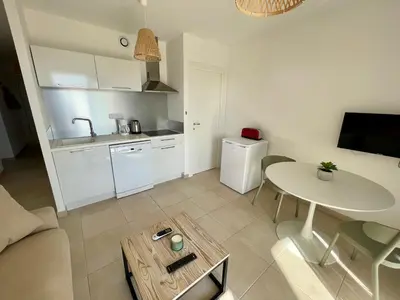 a small living room with a table and a kitchen at Résidence Marina Di Bravone in Linguizzetta