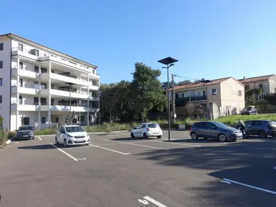 a parking lot with cars parked in front of a building at Apartment Paesu Pimpan by Interhome in Porto-Vecchio