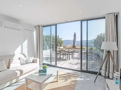 a living room with a white couch and a large window at Apartment château by Interhome in Porto-Vecchio