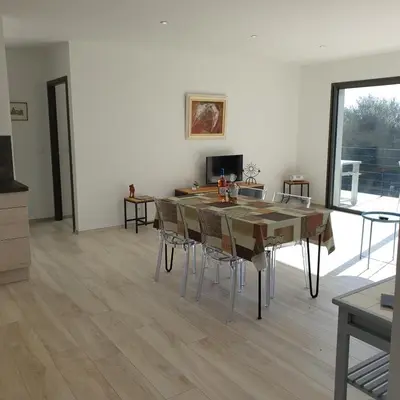 a dining room with a table and chairs at Villa Le Figuier 6 pers piscine chauffée 2 min plage en voiture in Sainte-Lucie de Porto-Vecchio