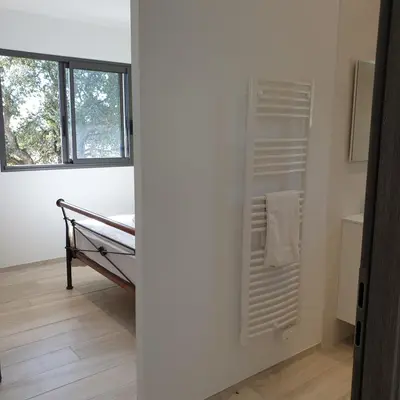 a room with a bed and a window at Villa Le Figuier 6 pers piscine chauffée 2 min plage en voiture in Sainte-Lucie de Porto-Vecchio