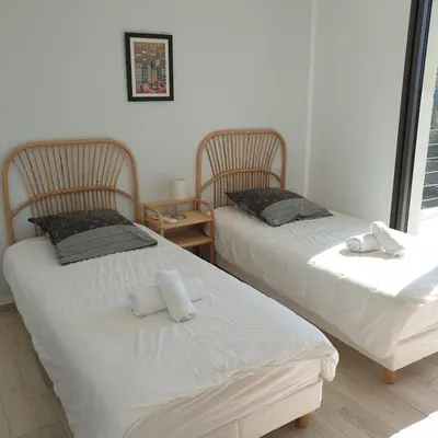 two beds sitting next to each other in a room at Villa Le Figuier 6 pers piscine chauffée 2 min plage en voiture in Sainte-Lucie de Porto-Vecchio
