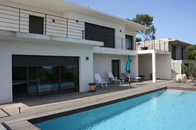 a villa with a swimming pool in front of a house at Villa Le Figuier 6 pers piscine chauffée 2 min plage en voiture in Sainte-Lucie de Porto-Vecchio